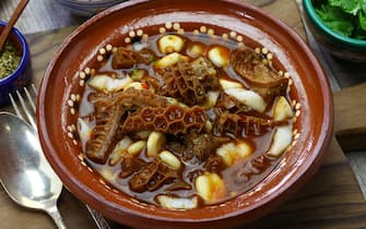 zuppe Menudo Rojo is a traditional mexican soup made with honeycomb tripe and hominy in broth with chile guajillo base.