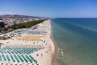 Colored umbrellas and people on a beach are seen in an aerial drone view in Alba Adriatica, Italy, on July 6th, 2024. (Photo by Lorenzo Di Cola/NurPhoto via Getty Images)