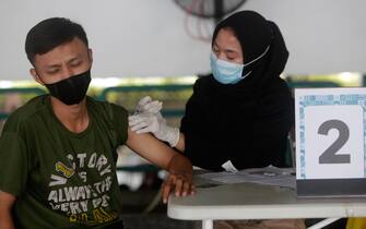 Un uomo indonesiano riceve il vaccino