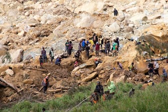 This undated handout photo taken by the UN Development Programme and released on May 28, 2024 shows locals digging at the site of a landslide at Mulitaka village in the region of Maip Mulitaka, in Papua New Guinea's Enga Province. Papua New Guinea moved to evacuate an estimated 7,900 people from remote villages near the site of a deadly landslide on May 28, as authorities warned of further slips. Some 2,000 people are already feared buried in a landslide that destroyed a remote highland community in the early hours of May 24. (Photo by Handout / UN DEVELOPMENT PROGRAMME / AFP) / RESTRICTED TO EDITORIAL USE - MANDATORY CREDIT "AFP PHOTO / UN DEVELOPMENT PROGRAMME  - NO MARKETING NO ADVERTISING CAMPAIGNS - DISTRIBUTED AS A SERVICE TO CLIENTS - NO ARCHIVE