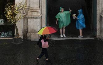 Passanti con ombrelli durante il temporale che si e' abbattuto su Roma, 13 giugno 2023 .  ANSA/ETTORE FERRARI  (turisti, ombrello, ombrelli, pioggia)