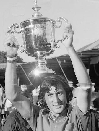 (Original Caption) 9/10/1972-Forest Hills, NY- Ilie Nastase of Romania displays his trophy after winning the U.S. Open Tennis Championships singles title on a cliff-hanging five-set victory over Arthur Ashe, 3-6, 6-3, 6-7, 6-4, 6-3, before a capacity crowd which alternately was annoyed and delighted by Ilie's performance.