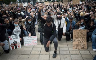 persone in ginocchio TOPSHOT - People raise their fist and stand on their knees as they demonstrate in Nantes, on June 8, 2020, during a 'Black Lives Matter' worldwide protests against racism and police brutality in the wake of the death of George Floyd, an unarmed black man killed while apprehended by police in Minneapolis. (Photo by Loic VENANCE / AFP) (Photo by LOIC VENANCE/AFP via Getty Images)