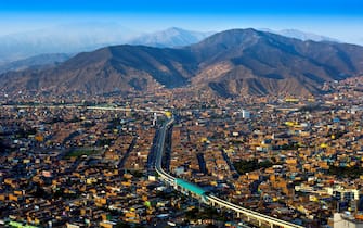 The desert mountains of Lima, Peru provide a backdrop to the new tracks of the Lima Metro, a rapid transit system.