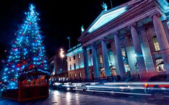 An illuminated Christmas Tree and light trails from traffic moving past the GPO up O'Connell Street, Dublin, Ireland during December.