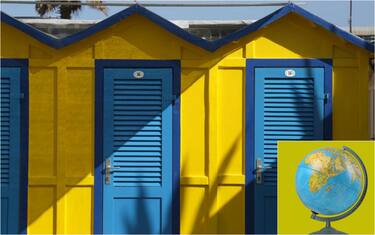 tre cabine di uno stabilimento balneare e un mappamondo