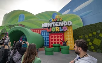 Guests take photos outside the entrance during a media preview of Super Nintendo World theme park at Universal Studios Hollywood in Universal City, California, US, on Thursday, Feb. 16, 2023. The interactive replica of Nintendo Co.'s lands and characters will open to the public on February 17. Photographer: Kyle Grillot/Bloomberg via Getty Images