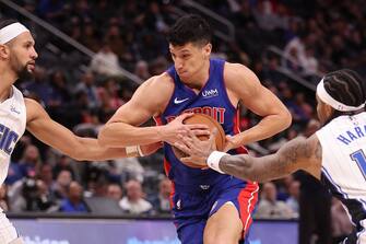 DETROIT, MICHIGAN - FEBRUARY 24: Simone Fontecchio #19 of the Detroit Pistons tries to drive between Jalen Suggs #4 and Gary Harris #14 of the Orlando Magic during the first half at Little Caesars Arena on February 24, 2024 in Detroit, Michigan. NOTE TO USER: User expressly acknowledges and agrees that, by downloading and or using this photograph, User is consenting to the terms and conditions of the Getty Images License.  (Photo by Gregory Shamus/Getty Images)