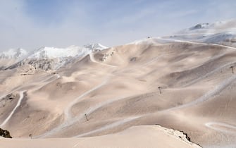 This photograph taken on March 15, 2022 shows sand from Sahara that fell overnight covering the snow, in Piau-Engaly ski ressort, southwestern France. - Orange cars, dusty subway corridors, a blocked and yellowish horizon: a thin layer of sand from the Sahara fell on March 14, 2022 night in Madrid and a good part of Spain, before going up towards France. (Photo by BASTIEN ARBERET / AFP) (Photo by BASTIEN ARBERET/AFP via Getty Images)