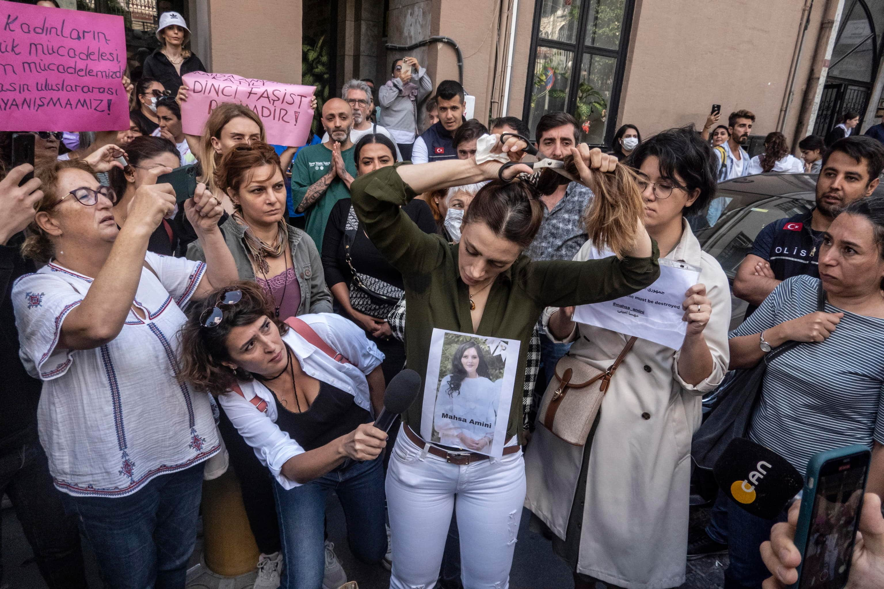 epa10196682 An Iranian woman cuts her hair during a protest outside the Iranian Consulate following the death of Mahsa Amini, in Istanbul, Turkey, 21 September 2022. Mahsa Amini, a 22-year-old Iranian woman, was arrested in Tehran on 13 September by the morality police, a unit responsible for enforcing Iran's strict dress code for women. She fell into a coma while in police custody and was declared dead on 16 September.  EPA/ERDEM SAHIN