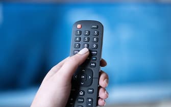 17 January 2023, Saxony, Dresden: A woman changes the channel with the remote control while watching TV. Photo: Sebastian Kahnert/dpa (Photo by Sebastian Kahnert/picture alliance via Getty Images)