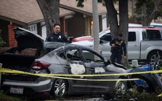 Police officers search the site where a small plane crashed into a San Diego, California, residential street on May 22, 2025. The Federal Aviation Authority said a Cessna 550 crashed at around 3:45 am local time. The neighborhood is close to the Montgomery-Gibbs Executive Airport. The crash left a "gigantic debris field" and damaged some 15 homes and parked cars, ABC News quoted the San Diego assistant fire chief as saying. (Photo by Sandy Huffaker / AFP)
