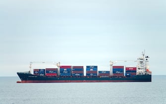 Container cargo ship, profile view, transport of shipping goods. Genova Italy - December 2021