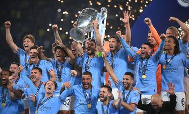 Manchester City's German midfielder #8 Ilkay Gundogan (C) lifts the European Cup trophy as they celebrate on the podium after winning the UEFA Champions League final football match between Inter Milan and Manchester City at the Ataturk Olympic Stadium in Istanbul, on June 10, 2023. (Photo by FRANCK FIFE / AFP) (Photo by FRANCK FIFE/AFP via Getty Images)