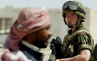 A British Soldier watches an Iraqi civilian whilst accompanying REME (Royal Electrical Mechanical Engineers) Captain Ken Jolley (unseen) on a 'Hearts and Minds' mission in southern Iraq, April 5, 2003.  U.S. President George W. Bush will meet British Prime Minister Tony Blair in Northern Ireland next week to discuss Iraq, the Northern Ireland peace process and the Middle East, Blair's office said in a statement on Friday.  REUTERS/POOL/Dan Chung-The Guardian