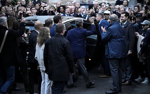 France's former president Nicolas Sarkozy (C) waves to his supporters as he leaves his residence to present himself to La Sante Prison for incarceration on a five-year prison sentence after being convicted of criminal conspiracy over a plan for late Libyan dictator Moamer Kadhafi to fund his 2007 electoral campaign, in Paris, on October 21, 2025. Nicolas Sarkozy, who has faced a flurry of legal woes since losing re-election in 2012, is to be jailed on October 21, 2025, over a scheme to acquire Libyan funding for his successful 2007 presidential run, becoming the first former head of a European Union country to serve time behind bars. The former French right-wing leader has appealed the verdict and denounced an "injustice". (Photo by JULIEN DE ROSA / AFP)