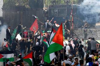 epa10925833 Protesters clash with security forces outside the US embassy during a protest following a strike on a hospital in the Gaza Strip, in Beirut, Lebanon, 18 October 2023. According to Palestinian authorities in Gaza hundreds of people have been killed in the explosion at a Gaza hospital on 17 October. Israel has denied responsibility and said a Palestinian Islamic Jihad (PIJ) rocket misfire caused the blast.  EPA/ABBAS SALMAN