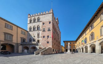 Piazza del Comune square with historic building of medieval Town Hall in Prato, Italy.