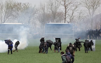 Protesters clash with riot mobile gendarmes during a demonstration called by the collective "Bassines non merci", the environmental movement "Les Soulevements de la Terre" and the French trade union 'Confederation paysanne' to protest against the construction of a new water reserve for agricultural irrigation, in Sainte-Soline, central-western France, on March 25, 2023. - More than 3,000 police officers and gendarmes have been mobilised and 1,500 "activists" are expected to take part in the demonstration, around Sainte-Soline. The new protest against the "bassines", a symbol of tensions over access to water, is taking place under thight surveillance on March 25, 2023 in the Deux-Sevres department. (Photo by Thibaud MORITZ / AFP) (Photo by THIBAUD MORITZ/AFP via Getty Images)