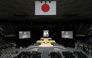 epa10208588 A portrait of former Japanese Prime Minister Shinzo Abe Shinzo Abe hangs above the stage during his state funeral at Nippon Budokan in Tokyo, Japan, 27 September 2022. Thousands of people are gathered in Tokyo to attend the state funeral for former prime minister Shinzo Abe, including foreign dignitaries and representatives from more than 200 countries and international organizations.  EPA/TAKASHI AOYAMA / POOL