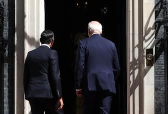 epa10737333 British Prime Minister Rishi Sunak (L) and US President Joe Biden (R) enter 10 Downing Street for talks in London, Britain, 10 July 2023. US President Biden is holding talks with Sunak and King Charles before heading on to the NATO summit in Lithuania.  EPA/ANDY RAIN