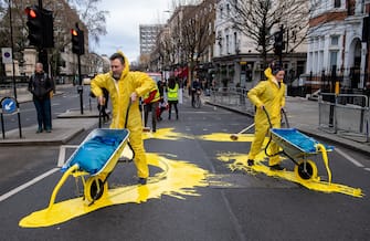 LONDON, ENGLAND - FEBRUARY 23: In this handout provided by Led By Donkeys, Activists from political campaign group Led By Donkeys, pour paint onto the road to create a giant Ukrainian flag outside the Russian Embassy on February 23, 2023 in London, England. The group created the flag using washable paint poured onto the road and then driven through by passing vehicles to show solidarity with Ukraine on the eve of the one year mark since the Russian invasion of Ukraine began. (Photo by Handout/Led By Donkeys via Getty Images)