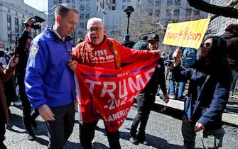 A supporter of former US president Donald Trump argues with the police outside the Manhattan District Attorney's office in New York on April 4, 2023. - Former US President Donald Trump is to be booked, fingerprinted, and will have a mugshot taken at a Manhattan courthouse on the afternoon of April 4, 2023, before appearing before a judge as the first ever American president to face criminal charges. (Photo by Leonardo Munoz / AFP) (Photo by LEONARDO MUNOZ/AFP via Getty Images)