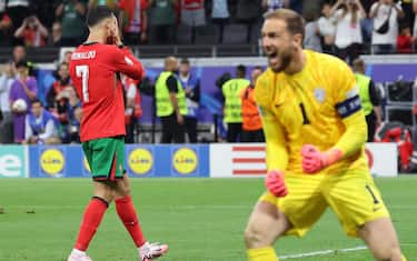 epa11451348 Cistiano Ronaldo of Portugal (L) gestures after failing to convert a penalty against Slovenia goalkeeper Jan Oblak during the UEFA EURO 2024 Round of 16 soccer match between Portugal and Slovenia, in Frankfurt Main, Germany, 01 July 2024.  EPA/MOHAMED MESSARA