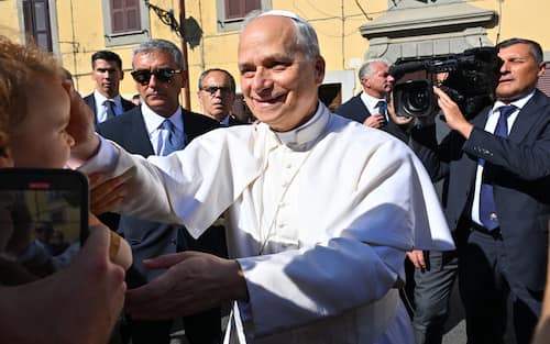 Pope Leo XIV  (C) greets people as he arrives for a two-week stay in the summer papal estate in Castel Gandolfo, 40 km southeast of Rome, on July 6, 2025. The newly elected Pope Leo XIV, revives a long-standing papal tradition paused under Francis, as Castel Gandolfo prepares to welcome a pope for the first time in over a decade. (Photo by Andreas SOLARO / AFP)