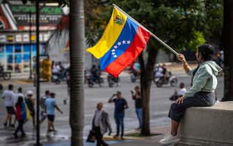 epaselect epa11507582 A woman holds a flag during a protest against the results of the presidential elections, in Caracas,Venezuela, 29 July 2024. According to the first report from the National Electoral Council (CNE), Maduro was re-elected for a third consecutive term in the elections held on 28 July, in which he obtained 51.2 percent of the votes (5,150,092 votes), while the standard-bearer of the majority opposition, Edmundo Gonzalez Urrutia, obtained 4,445,978 votes, which represents 44.2 percent of the votes. The opposition is calling for the release of the full vote count.  EPA/Henry Chirinos