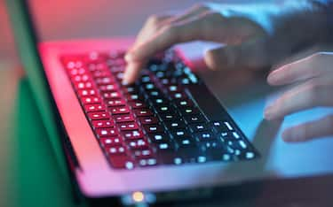 Hacker working on illuminated laptop at office