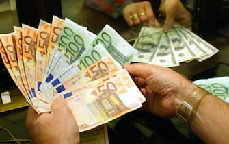 Un uomo mostra diverse banconote da 50, 100 e 150 euro