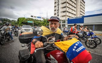 epa11507586 A man on a motorcycle rides down a street during a protest against the results of the presidential elections on Monday, in Caracas, Venezuela, 29 July 2024. According to the first report from the National Electoral Council (CNE), Maduro was re-elected for a third consecutive term in the elections held on 28 July, in which he obtained 51.2 percent of the votes (5,150,092 votes), while the standard-bearer of the majority opposition, Edmundo Gonzalez Urrutia, obtained 4,445,978 votes, which represents 44.2 percent of the votes. The opposition is calling for the release of the full vote count.  EPA/Henry Chirinos