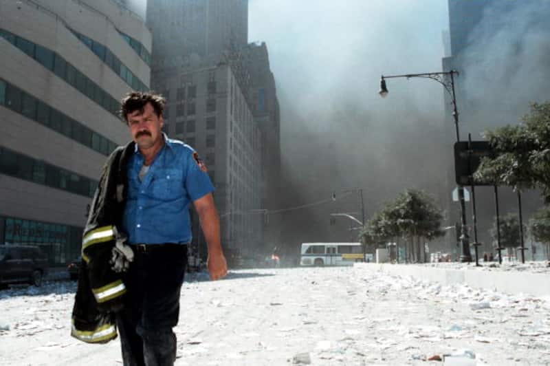 NEW YORK - SEPTEMBER 11:  An unidentified New York City firefighter walks away from Ground Zero after the collapse of the Twin Towers September 11, 2001 in New York City. The World Trade Center's Twin Towers and the Pentagon were attacked by terrorists using commercial airliners as missiles.  (Photo by Anthony Correia/Getty Images)