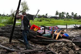 epa10521049 A man tries to recover some belongings in a house destroyed by the storm Freddy in Quelimane, Mozambique, 13 March 2023. This is one of the longest lasting storms ever, after it formed at the beginning of February in the Asian seas, crossing the entire Indian Ocean to the east African coast.  EPA/ANDRÉ CATUEIRA