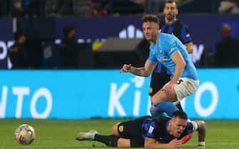 Inter Milan's Argentine forward #10 Lautaro Martinez falls while vying for the ball with Napoli's Kosovo defender #13 Amir Rrahmani during the Italian Super Cup final football match between Napoli and Inter Milan at Al-Awwal Park Stadium in Riyadh, on January 22, 2024. (Photo by Fayez NURELDINE / AFP)