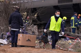 epa10496412 Policemen and rescuers at the scene of a train collision, near Larissa city, Greece, 01 March 2023. At least 32 people were killed and more than 85 were injured when a passenger train collided with a freight train, in Tempi, central Greece, near the city of Larissa, the Greek Fire Service said. Out of the 85 injured persons, 53 still remain in hospital, according to the spokesperson of the Fire Service, Vassilis Vathrokogiannis. Rescue workers continue the search for survivors focusing on the first two carriages of the passenger train.  EPA/ACHILLEAS CHIRAS