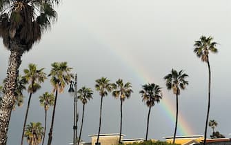 A rainbow appears between palm trees during a winter storm that blanketed the region with rain, snow, and hail in Redondo Beach, California, on February 25, 2023. - Heavy snow fell in southern California as the first blizzard in a generation pounded the hills around Los Angeles, with heavy rains threatening flooding in other places. (Photo by Patrick T. Fallon / AFP) (Photo by PATRICK T. FALLON/AFP via Getty Images)