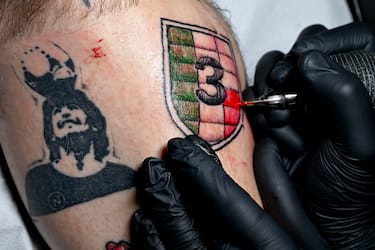 Il tatuatore Salvatore Russo impegnato nel suo laboratorio nella realizzazione di uno scudetto con il numero 3 richiesto da un tifoso del Napoli, 16 febbraio 2023.
ANSA / CIRO FUSCO