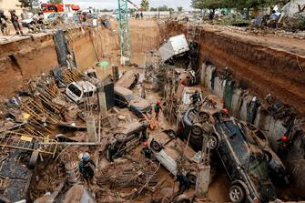 epaselect epa11696955 Civil Guard officers search for survivors inside cars trapped under the foundations of a building under construction in the town of Paiporta, Valencia, eastern Spain, 02 November 2024. According to the Integrated Operational Coordination Center (CECOPI), more than 200 people have died in Valencia and neighboring provinces after floods caused by a DANA (high-altitude isolated depression) weather phenomenon hit the east of the country. According to Spain's national weather agency (AEMET), on 29 October 2024 Valencia received a year's worth of rain, causing flash floods that destroyed homes and swept away vehicles.  EPA/Biel Alino
