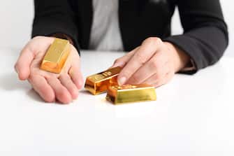 A Business woman presents Gold bullion bar
