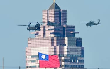 A US-made CH-47SD helicopter flies a national flag past a building during a rehearsal ahead of the May 20 Taiwan President-elect Lai Ching-te' inauguration ceremony in Taipei on May 15, 2024. (Photo by Sam Yeh / AFP) (Photo by SAM YEH/AFP via Getty Images)