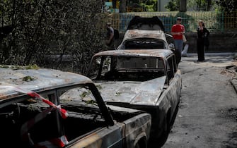 epa10662895 People stand near damaged cars after debris fell outside an apartment building in a drone strike in Kyiv (Kiev), Ukraine, 30 May 2023, amid the Russian invasion. At least one person died and seven others injured after a Russian strike against the the Ukrainian capital, the Kyiv City Military Administration said on telegram. On 30 May Russian forces launched 31 'kamikaze' drones on Ukraine, 29 of which were shot down, said the Air Force Command of the Armed Forces of Ukraine. Russian troops entered Ukrainian territory in February 2022, starting a conflict that has provoked destruction and a humanitarian crisis.  EPA/SERGEY DOLZHENKO