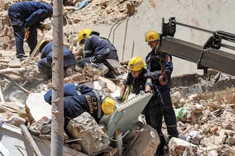 Civil defence first responders search through rubble at the scene of a collapsed 13-storey-building in the Sidi Bishr district of Egypt's northern city of Alexandria on June 26, 2023. (Photo by Hazem GOUDA / AFP)