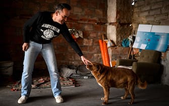Leonel Costa, 38 years old, owner of Bobi, a 30 years old Portuguese dog that has been declared the world's oldest dog by Guinness World Records, caresses his pet at their home in the village of Conqueiros near Leiria. (Photo by PATRICIA DE MELO MOREIRA / AFP) (Photo by PATRICIA DE MELO MOREIRA/AFP via Getty Images)
