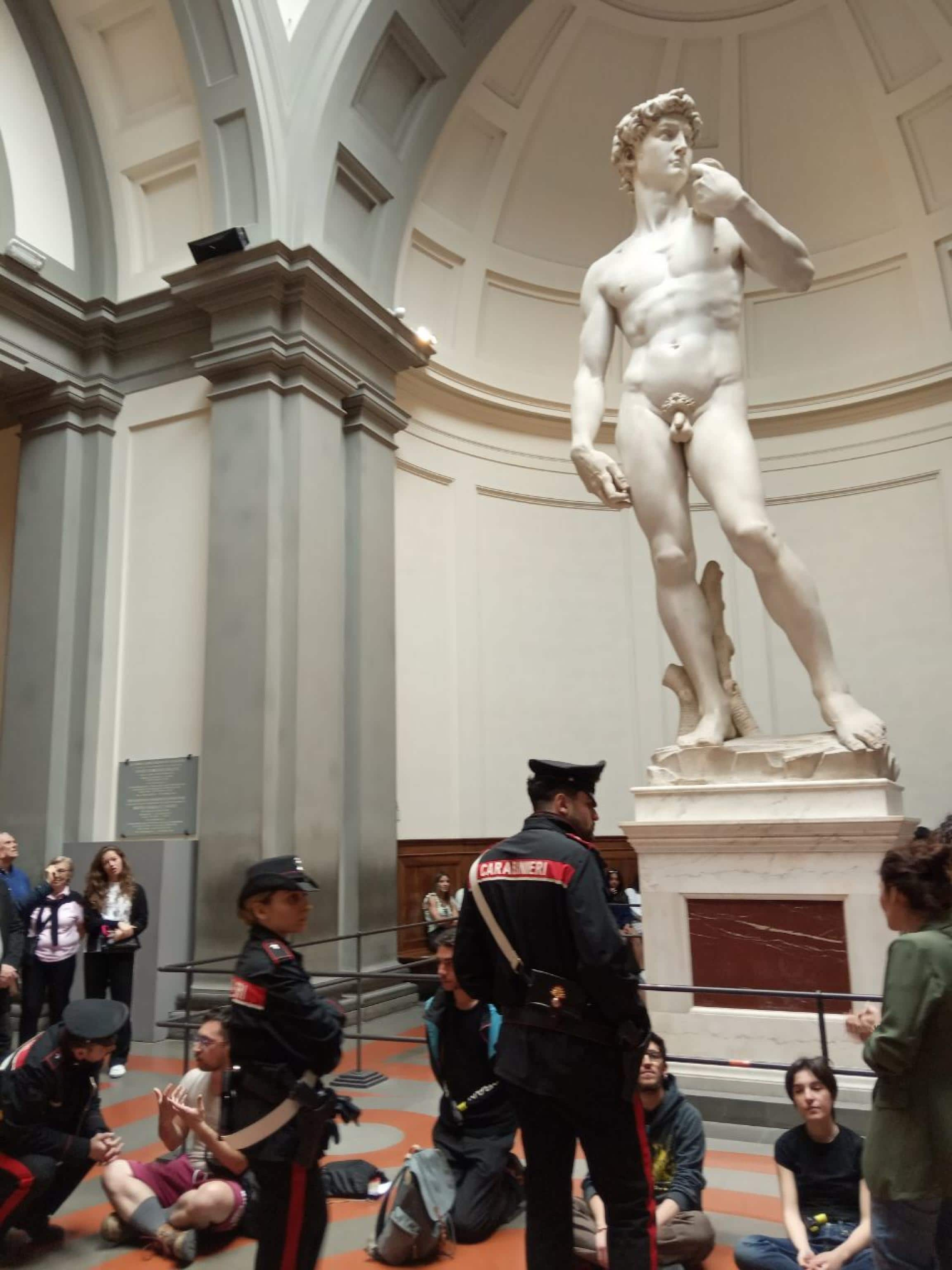 Nuovo blitz di Ultima Generazione a Firenze dove oggi, alle 12:20, quattro attivisti si sono seduti e incatenati alla ringhiera che protegge il David di Michelangelo, all'interno della Galleria dell'Accademia, srotolando uno striscione con scritto "Fondo Riparazione". Altri quattro attivisti, spiega una nota, hanno fatto partire la Canzone di Maggio di De André, e distribuito volantini sull'alluvione di Campi Bisenzio (Firenze). Il brano ha accompagnato un appello per partecipare alle iniziative di Ultima Generazione in programma a Roma l'11 e 25 maggio. Sul posto sono poi intervenuti i carabinieri, 7 aprile 2024. ANSA/US ULTIMA GENERAZIONE +++ NO SALES, EDITORIAL USE ONLY +++ NPK +++