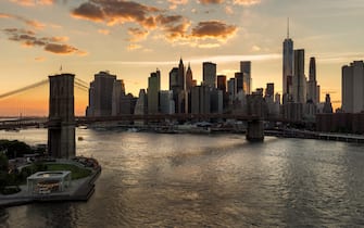 Lower Manhattan skyscrapers and Financial District skyline at sunset with the Brooklyn Bridge over the East River, New York CIty