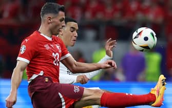 epa11433096 Fabian Schaer of Switzerland (L) and Jamal Musiala of Germany (R) in action during the UEFA EURO 2024 group A soccer match between Switzerland and Germany, in Frankfurt am Main, Germany, 23 June 2024.  EPA/CHRISTOPHER NEUNDORF