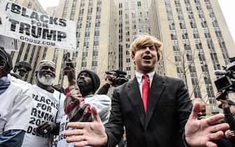 A protestor, center, next to supporters of former US President Donald Trump outside criminal court in New York, US, on Tuesday, April 4, 2023. Trump, the first former US president to be indicted, will plead not guilty when he appears in a Manhattan state court Tuesday to face criminal charges, his defense lawyer said. Photographer: Stephanie Keith/Bloomberg via Getty Images