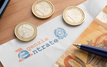Carrara,. Italy - January 18, 2022 - Letter from the revenue agency (agenzia delle entrate) with a fifty euro banknote, one euro coins and a calculato